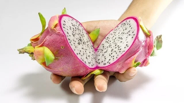 Dragon fruit cut in half to reveal its seeded flesh